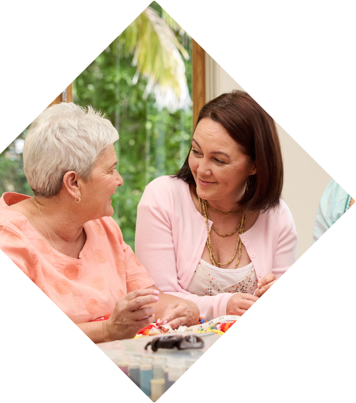 Two Wahine (women) talking whilst sewing a quilt